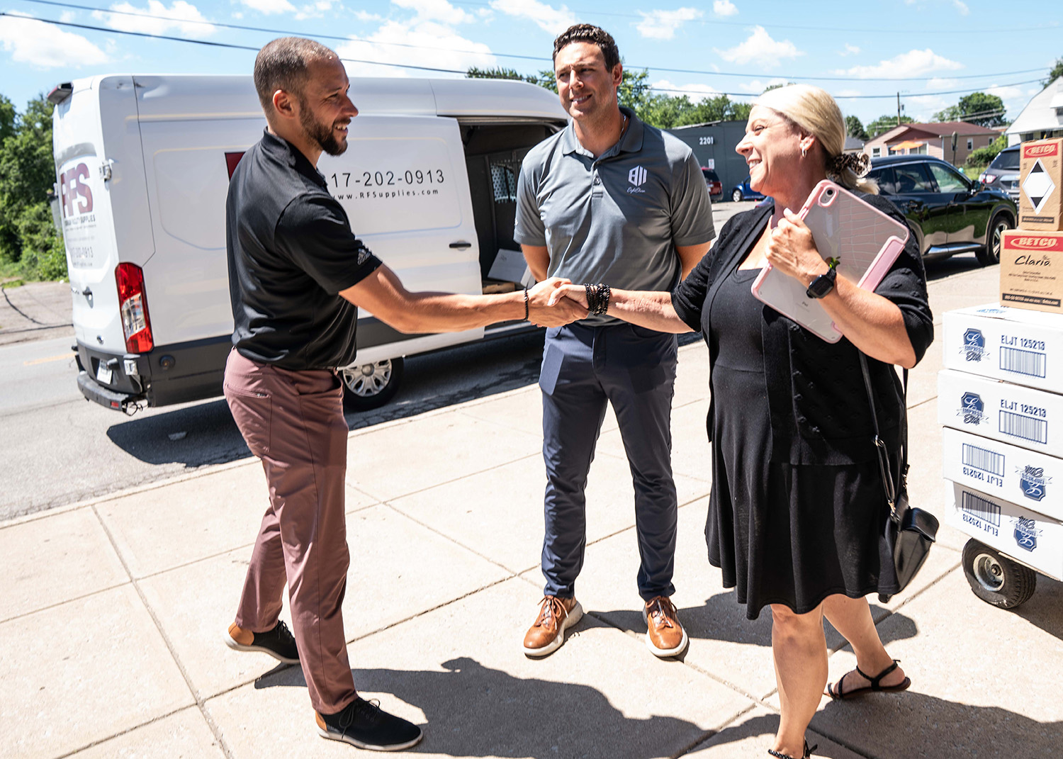 Nate Browning - VP of Communication, Partnership & Inclusion, and Jake Baldwin - Director of Information Technology and Procurement, shaking hands with the Boys & Girls Club Representative 